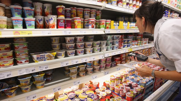 жена проверява млечните продукти в супермаркет жена проверява млечните продукти в супермаркет