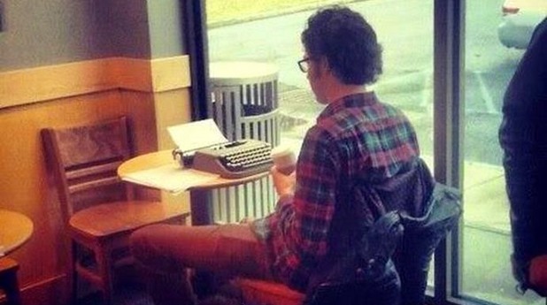 Хипстър твори на пишеща машина в Starbucks Хипстър твори на пишеща машина в Starbucks